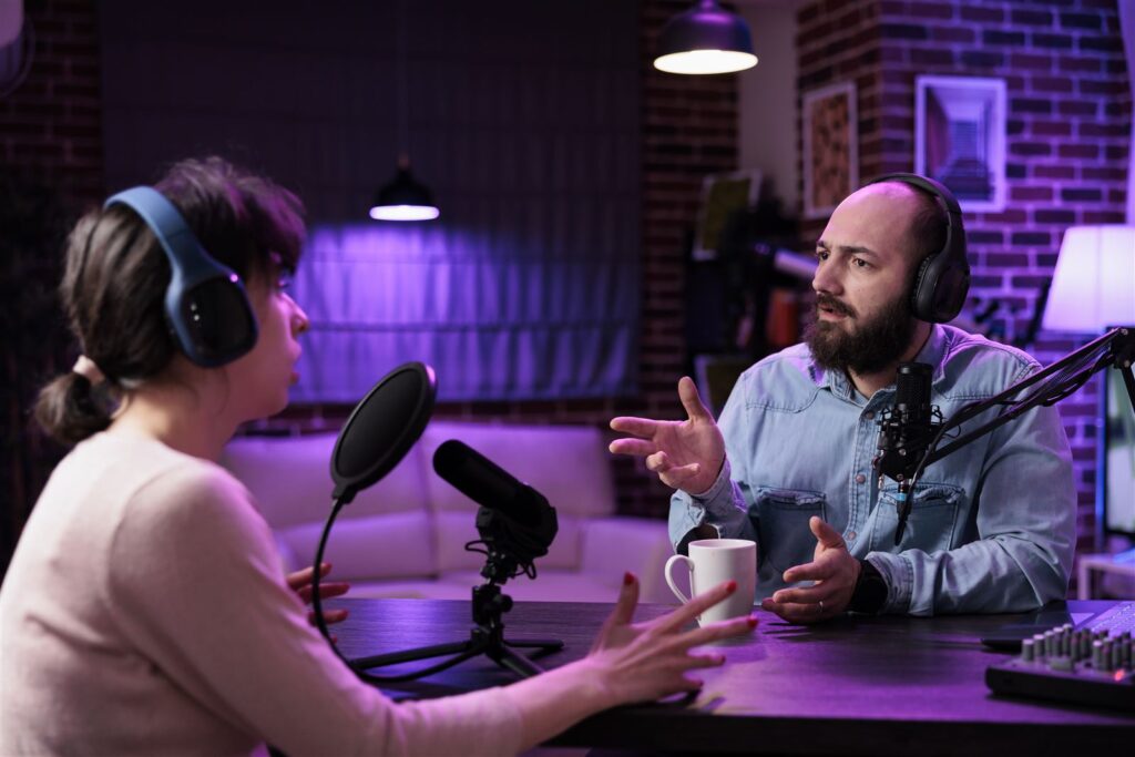 Two hosts recording a podcast episode with microphones